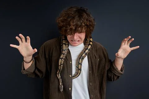 A man has a panic attack having snake on his shoulders Stock Photos