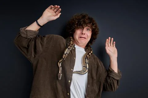 A man has a panic attack having snake on his shoulders Stock Photos