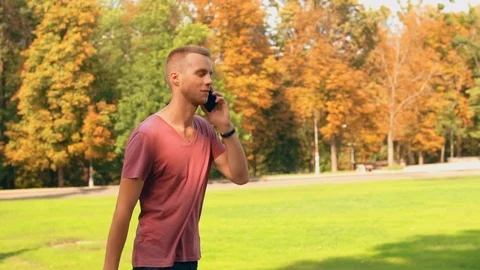 Man has phone conversation walking in city Stock Footage 99865804