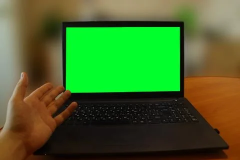 A man has problems with a computer and shows the green screen with his hand Stock Photos