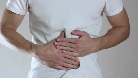 The man has a stomach ache. Close up. Isolated on a gray background. Stock Footage 141367562
