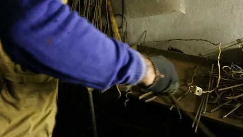 The man has work-worn hands, he spins a tangled metal rod. Special fixture: vise Stock Footage 83073305