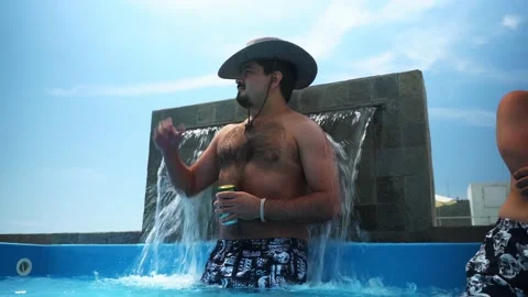 A man with a hat and a can of beer in his hand posing with the output of cold Video stock 173506628
