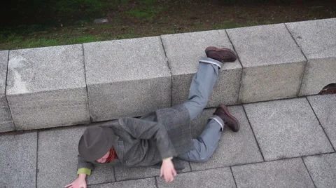 Man with the hat and coat roll on the ground and walk on all fours Stock Footage 48021159