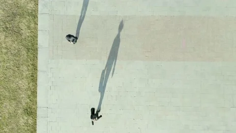 Man in hat and a guitar case walks along the sidewalk of the city, seen Stock Footage 165305440