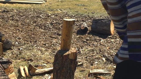 Man in hat with axe chopping firewoods in mountains. Guy with axe Stock Footage 101275553