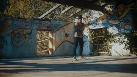 Man in hat dancing in building with no roof 스톡 동영상 117917971