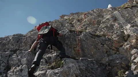 A man in a hat down the mountain on a rope. 스톡 동영상 97767130