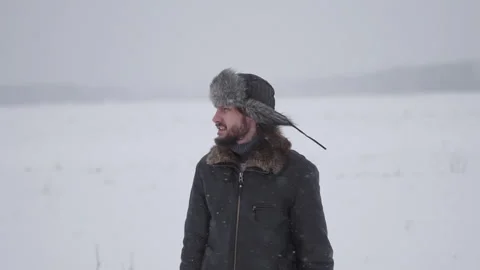 A man in a hat with earflaps in the snow Stock Footage 257891193