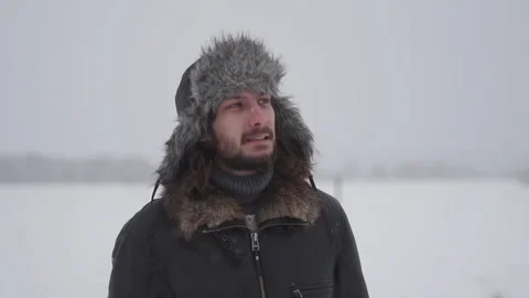 A man in a hat with earflaps in the snow Stock Footage 257891215