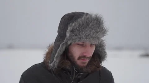 A man in a hat with earflaps in the snow Stock Footage 257891325