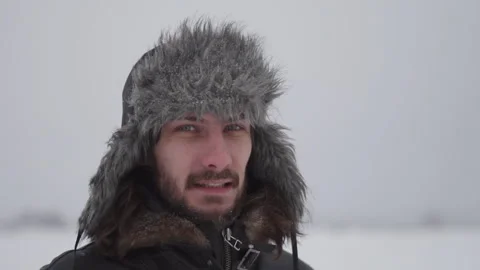 A man in a hat with earflaps in the snow Stock Footage 257891340