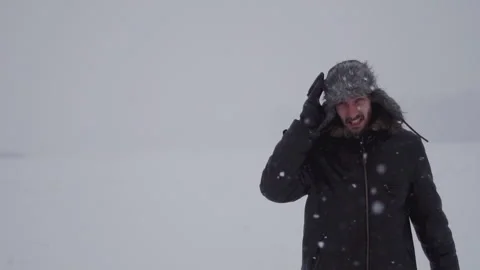 A man in a hat with earflaps in the snow Stock Footage 257891360