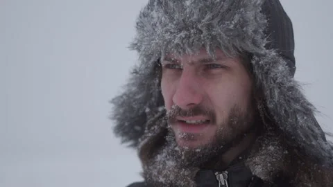 A man in a hat with earflaps in the snow Stock Footage 257891399
