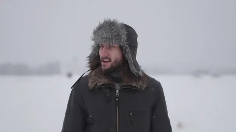 A man in a hat with earflaps in the snow Stock Footage 258270681