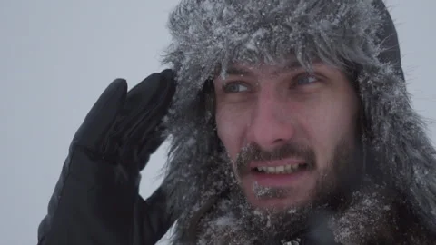 A man in a hat with earflaps in the snow Stock Footage 258270745