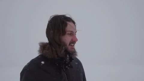 A man in a hat with earflaps in the snow Stock Footage 258270778