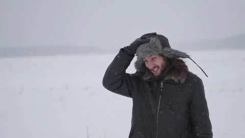 A man in a hat with earflaps in the snow Stock Footage 258569589