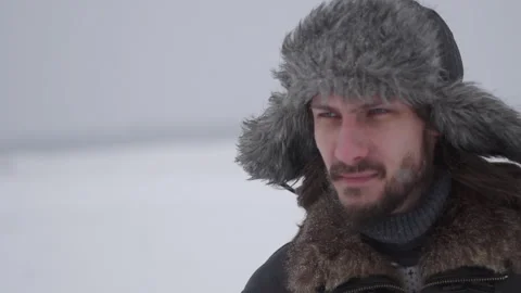 A man in a hat with earflaps in the snow Stock Footage 258569670