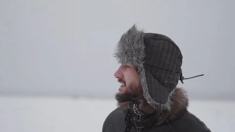 A man in a hat with earflaps in the snow Stock Footage 258733227