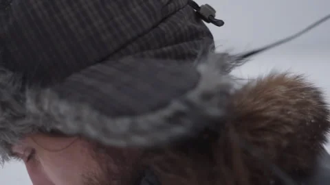 A man in a hat with earflaps in the snow Stock Footage 258733355