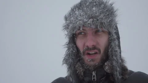 A man in a hat with earflaps in the snow Stock Footage 258733483