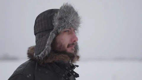 A man in a hat with earflaps in the snow Stock Footage 259293206