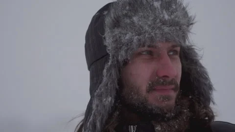 A man in a hat with earflaps in the snow Stock Footage 259293349