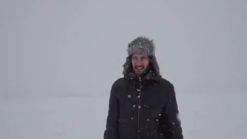 A man in a hat with earflaps in the snow Stock Footage 259293377