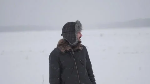 A man in a hat with earflaps in the snow Stock Footage 259689343
