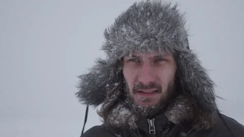A man in a hat with earflaps in the snow Stock Footage 259689455