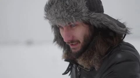 A man in a hat with earflaps in the snow Stock Footage 259689468