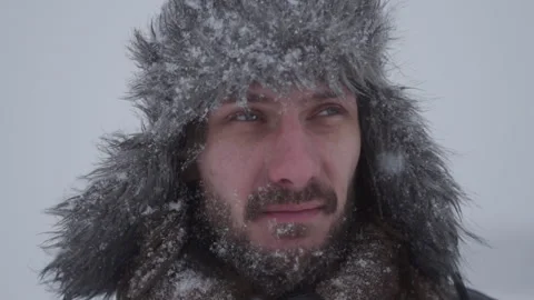 A man in a hat with earflaps in the snow Stock Footage 259689521