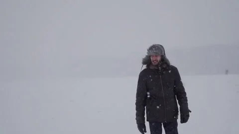 A man in a hat with earflaps in the snow Stock Footage 260800695