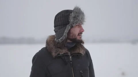 A man in a hat with earflaps in the snow Stock Footage 260800802