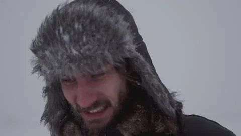 A man in a hat with earflaps in the snow Stock Footage 260800877