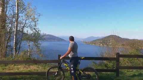 Man with hat enjoying panoramic view of Lake Maggiore, FPV Видео 280881903