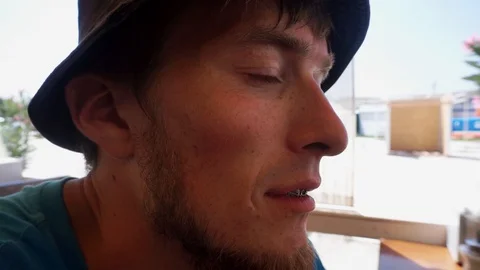 Man in the hat is looking forward and then turns to the camera and makes a 스톡 동영상 102785017