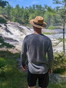 A man in hat looking at a waterfall in rural Ontario Stock-Fotos