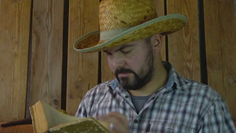 A man in a hat reading an old book 4K Video stock 95925374