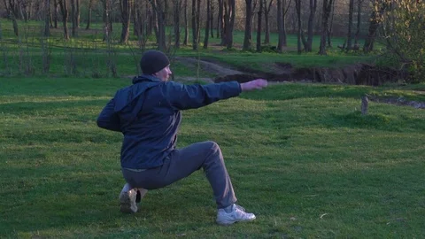 The Man in the Hat Sit Practicing Kata Karate Kyokushin at Dawn in the Forest Stock Footage 74693052