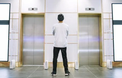 Man in hat standing near the elevator Stock Photos