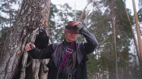 Man in hat by tree in forest, enjoying winter recreation Video stock 270492414
