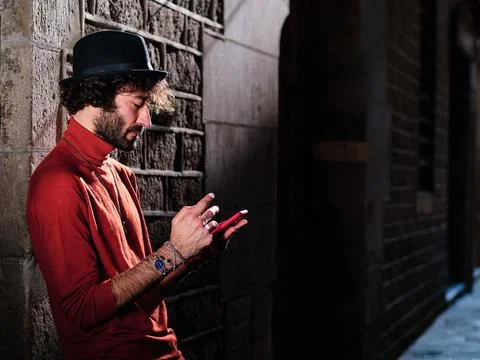 Man with a hat using a mobile in the street Stock Photos