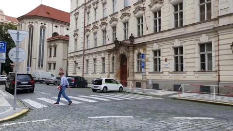 A man in a hat walks through the old center of Prague Stock Footage 157593761