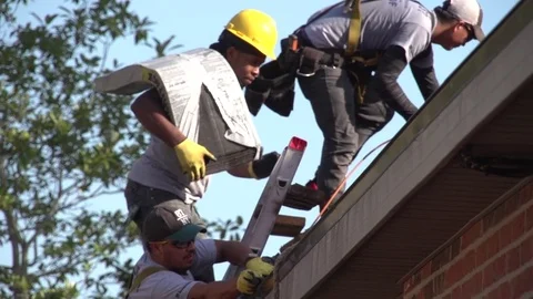 Man Hauling Stack of Roof Shingles up a Ladder onto Roof 動画素材 85358715