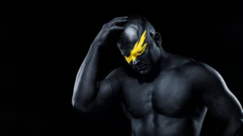 Man have a good idea. Bodybuilder athlete with yellow face art and black body Stock Footage 128889933