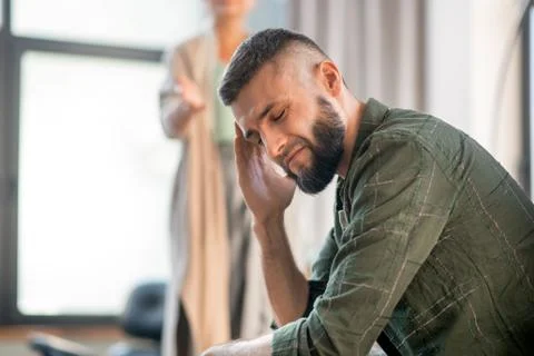 Man having awful headache while having psychological investigation Stock Photos