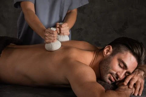 Man having back massage with pouche Stock Photos