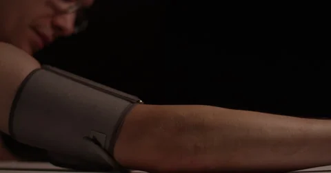 Man having blood pressue measured- Isolated on black background Stock Footage